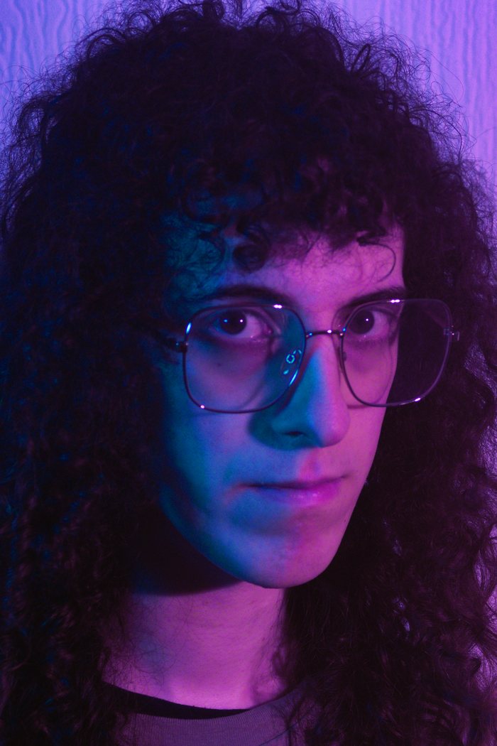 Portrait of Francesca Iannucci in glasses, lit in blue and pink